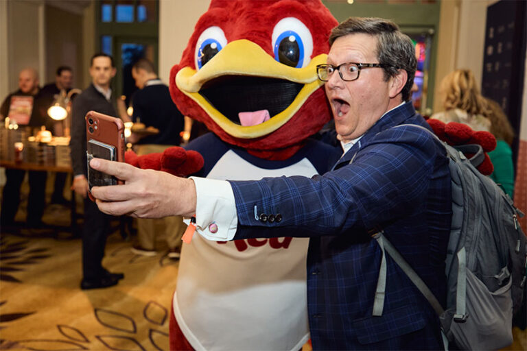 Man taking a selfie with a mascot