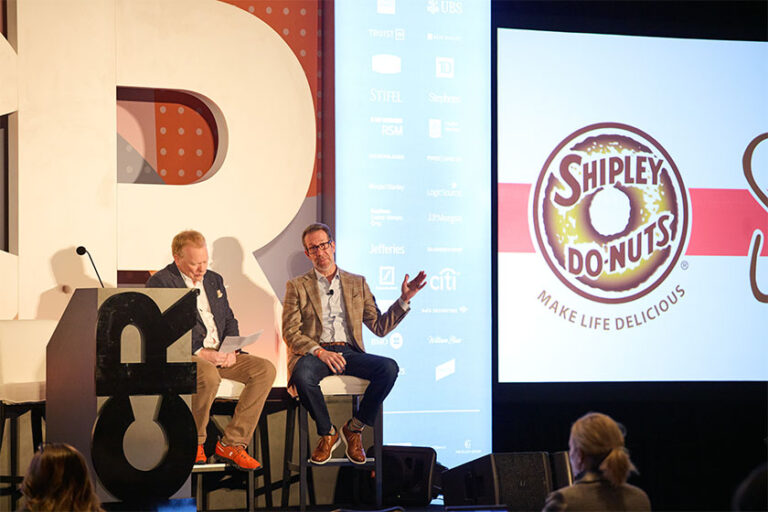 Two men speaking on stage