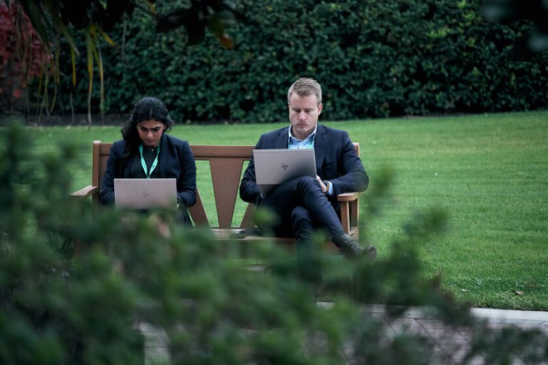 Two people working on laptops